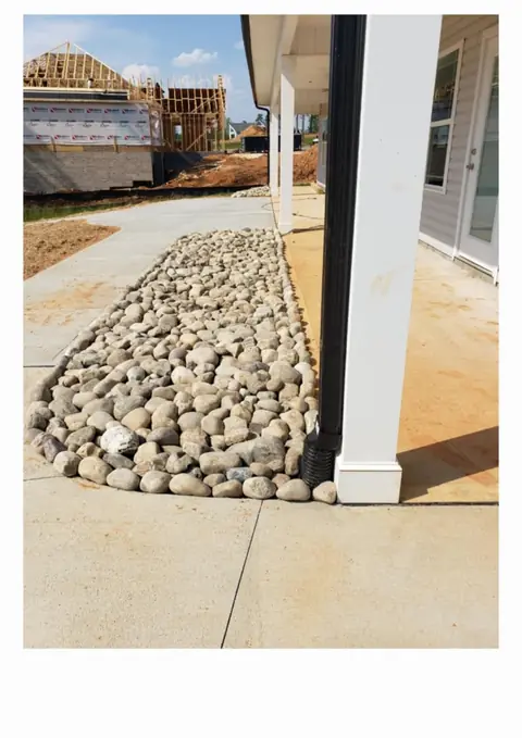 River rock drainage bed installed beside a house in Charlotte, NC